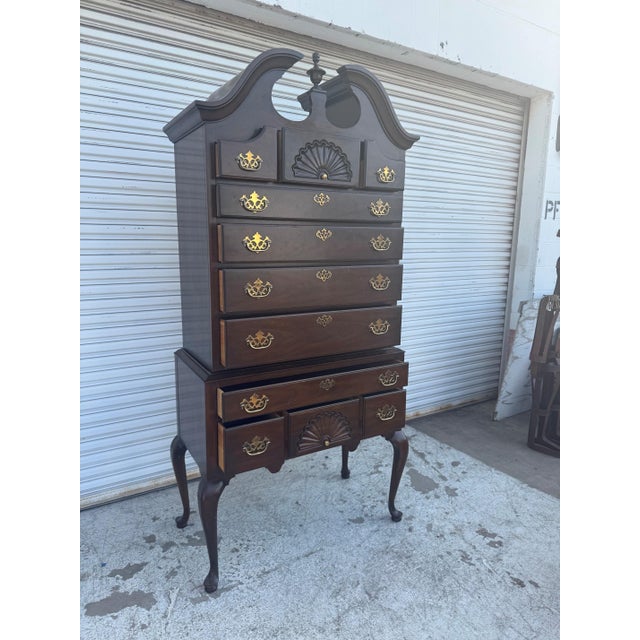 Elegant vintage Drexel highboy chest of drawers featuring a tall silhouette, multiple drawers, and classic traditional...