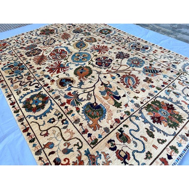 This artistic hand-knotted wool area rug features a spectacular, highly detailed Suzani tribal design. The open ivory...