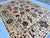This artistic hand-knotted wool area rug features a spectacular, highly detailed Suzani tribal design. The open ivory...