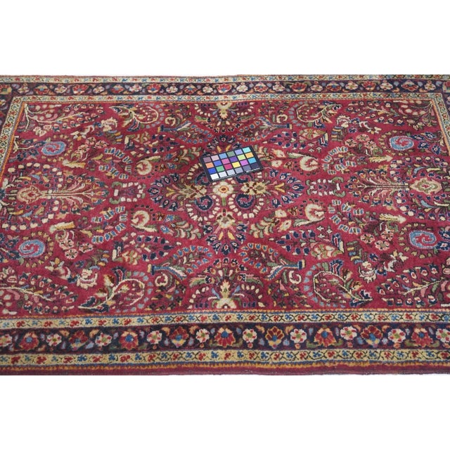 From Arak Province in western Persia, this village scatter in the “American” manner shows a red field with four ivory dot...