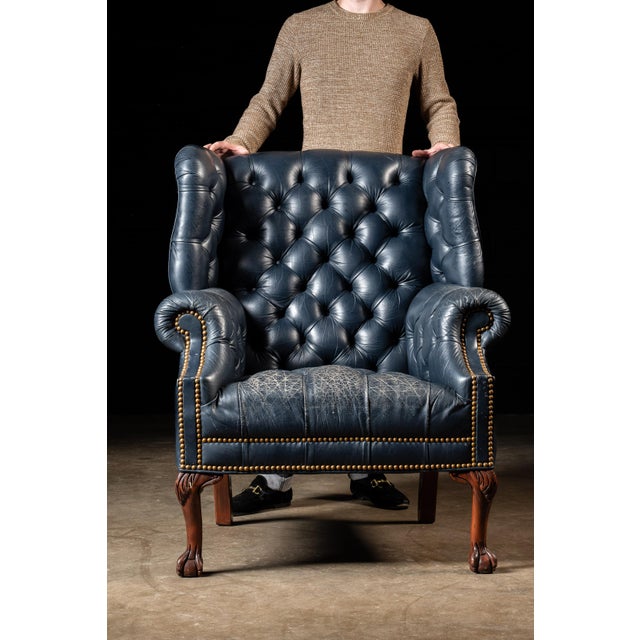 Vintage leather armchair on clawfoot legs. This vintage armchair features a deep blue finish over tufted leather and a...