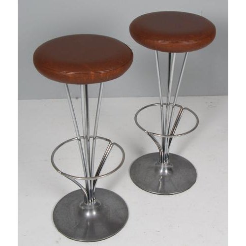 Piet Hein pair of bar stools original upholstered with patinated leather leather. Made by Fritz Hansen. This piece is...