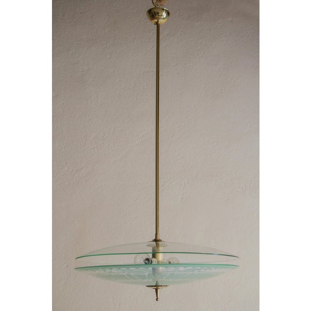 Beautiful Italian Mid-Century Modern double disc pendant lamp in the aquamarine shade color, 1950. Polished brass...
