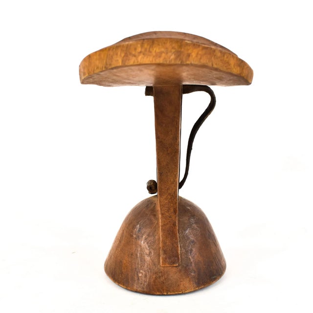 The Turkana wood headrest is a captivating embodiment of functional artistry originating from the Turkana people of East...