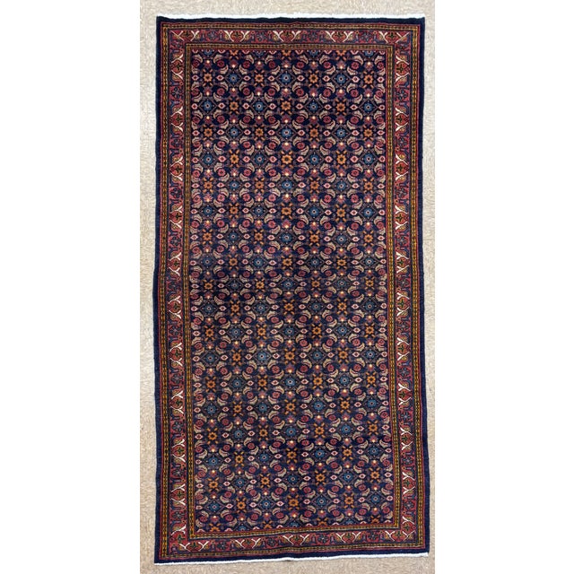 Antique hand-knotted runner from the Arak region of central Iran, featuring a dense allover Herati-style pattern set on a...