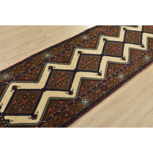 An authentic vintage tribal Hamedan runner hand-knotted with fine wool and natural dyes. This nomadic rug features a row...
