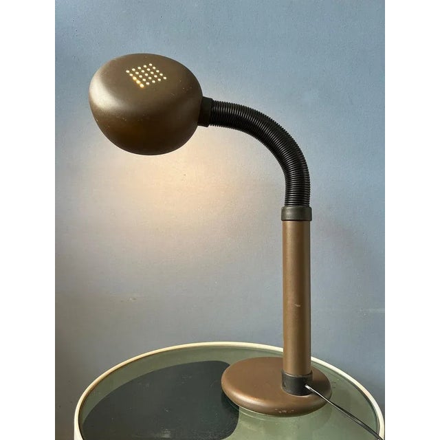 Space age table lamp with easily adjustable arm and shade. The black arm allows you to position the lamp in any way...
