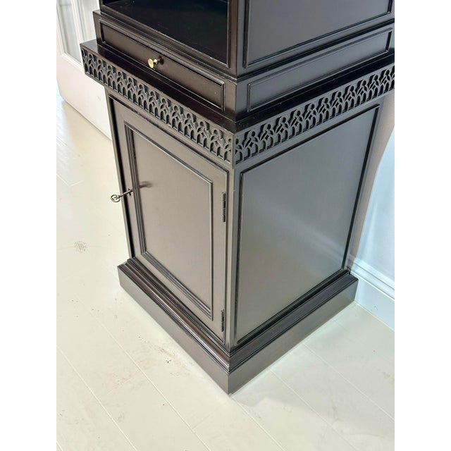A striking ebonized obelisk-form étagère by Baker Furniture from the Stately Homes Collection, inspired by classical...