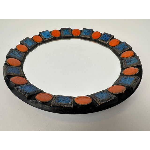 Vintage West Germany mirror. Ceramic decorated with glazed tiles. Diameter: 20cm. Depth: 3cm. Designed for hanging....