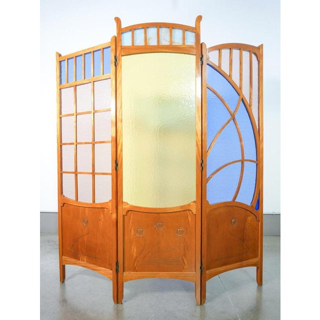 Art nouveau-style screen made of wood and polychrome glass, featuring three panels with double-action hinges. Mid-20th...