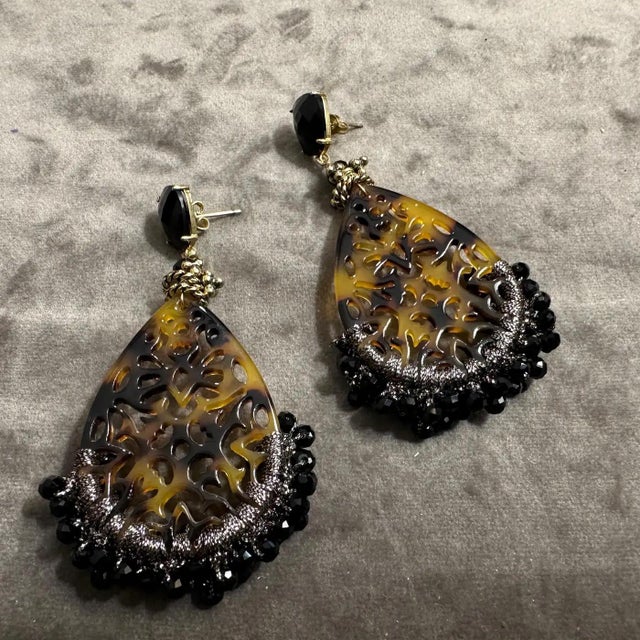 These dramatic drop earrings are a captivating fusion of intricate craftsmanship and bold design. Featuring large...
