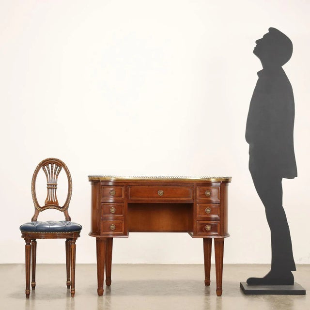 Bean-shaped writing desk, in walnut-stained beech, top with blue leather insert and pierced brass balustrade. Central...