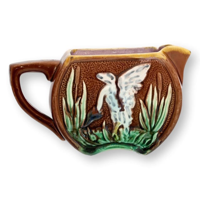 19th century English Aesthetic Movement majolica creamer decorated with a raised crane motif surrounded by marsh reeds...