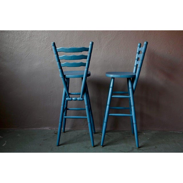 These cool rustic bar stools are touching. In turned wood painted blue-gray, they are simple and authentic, with country...