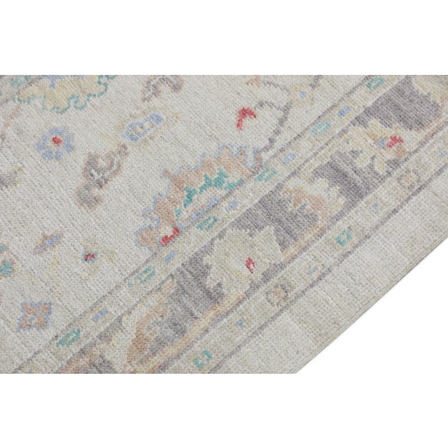 This modern Turkish Oushak rug is a stunning piece of art that has been handwoven using traditional techniques by skilled...