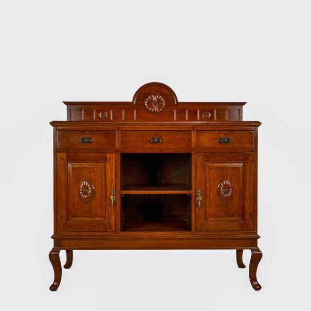 Beautiful English Edwardian oak sideboard dating to the early 20th century, featuring carved sunflower motifs, paneled...
