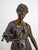 Bronze sculpture of a young woman with a child and birds on a marble pedestal. The statue is signed on the reverse side by...