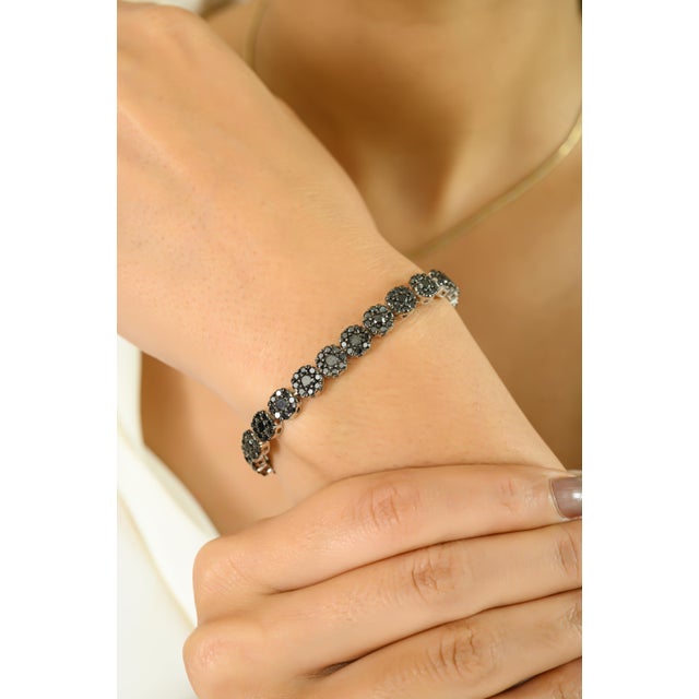 Make a bold and sophisticated statement with this stunning tennis bracelet featuring 9.19 carats of rich black diamonds....