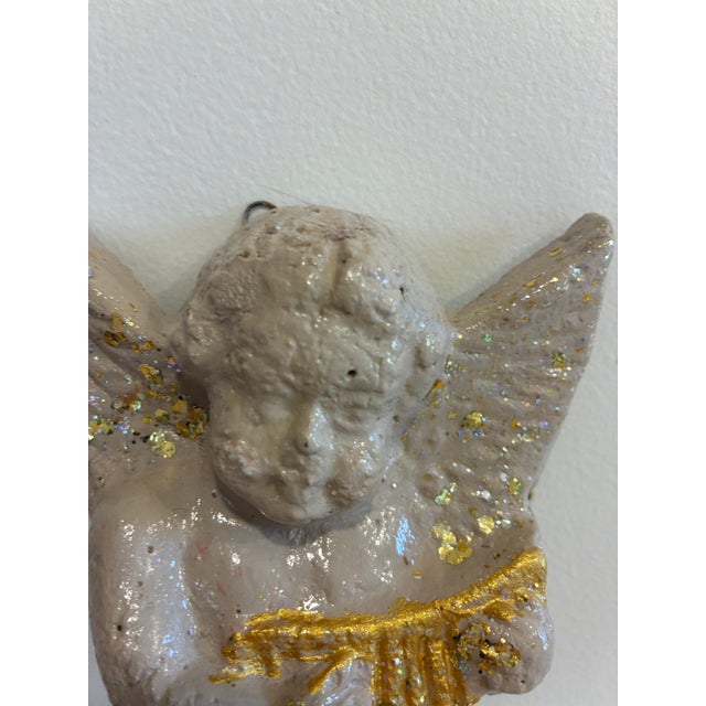 A charming vintage chalkware wall plaque depicting a cherub angel playing a harp. Hand-painted in soft pastel tones and...