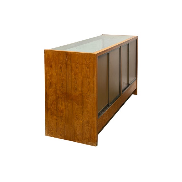 This vintage, mid-century modern style retail showcase features a warm, medium-toned wood veneer frame with clean...