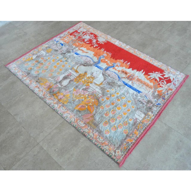 A stunning vintage peacock rug, machine made in germany. Muted colors with detailed portrait of a peacock perched in a...