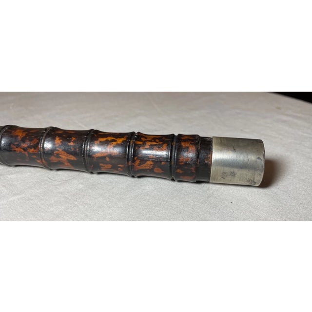 This antique Asian sterling silver and hand-carved wood walking stick is a unique piece that exudes craftsmanship and...