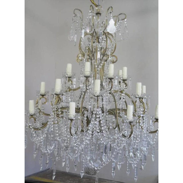 Monumental Italian 24 light crystal beaded arm chandelier adorned with garlands of crystal swags, crystal spheres, and...