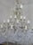 Monumental Italian 24 light crystal beaded arm chandelier adorned with garlands of crystal swags, crystal spheres, and...