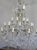 Monumental Italian 24 light crystal beaded arm chandelier adorned with garlands of crystal swags, crystal spheres, and...