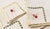 A charming set of four vintage hand-embroidered linen napkins featuring delicate floral bouquets, hand-stitched drawn-...