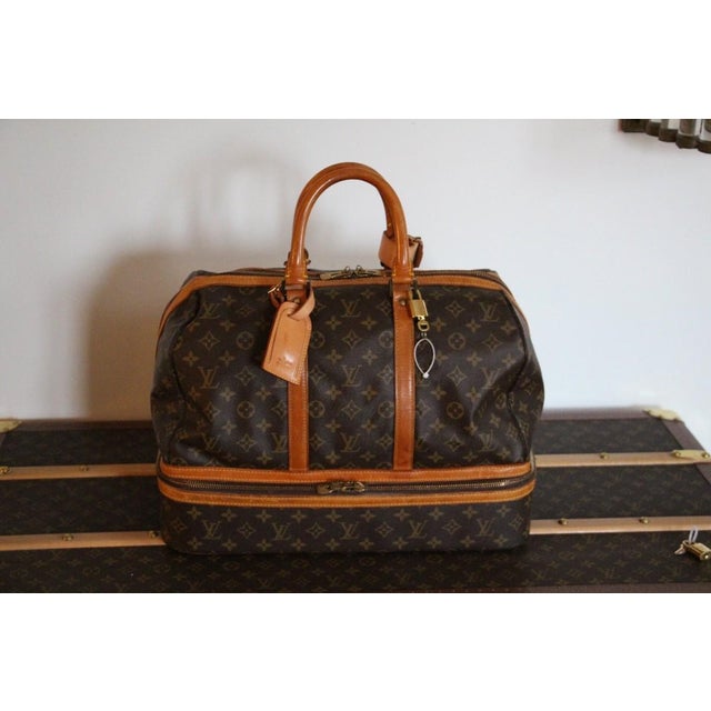 This Louis Vuitton large bag is a very unusual model. Horizontally, it opens to a rigid compartment to put fragile items...
