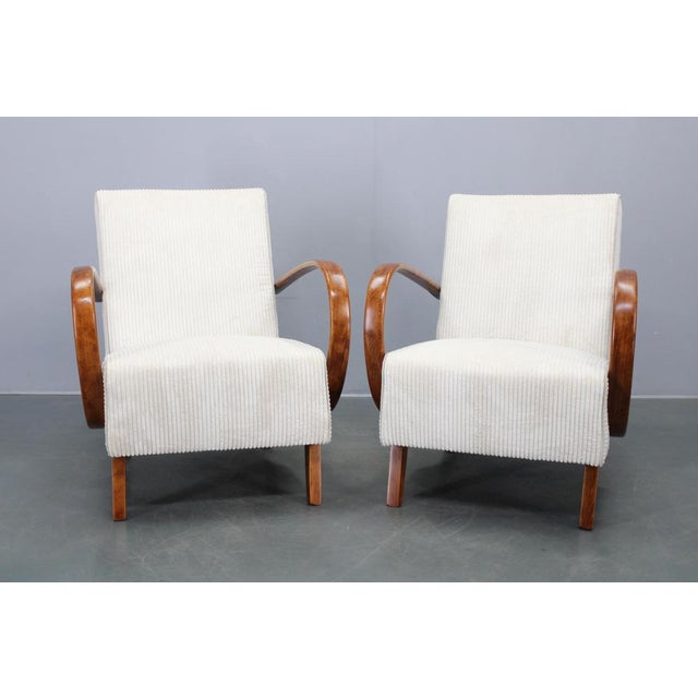 This elegant pair of Art Deco armchairs was designed by Jindřich Halabala and produced in Czechoslovakia during the 1940s....