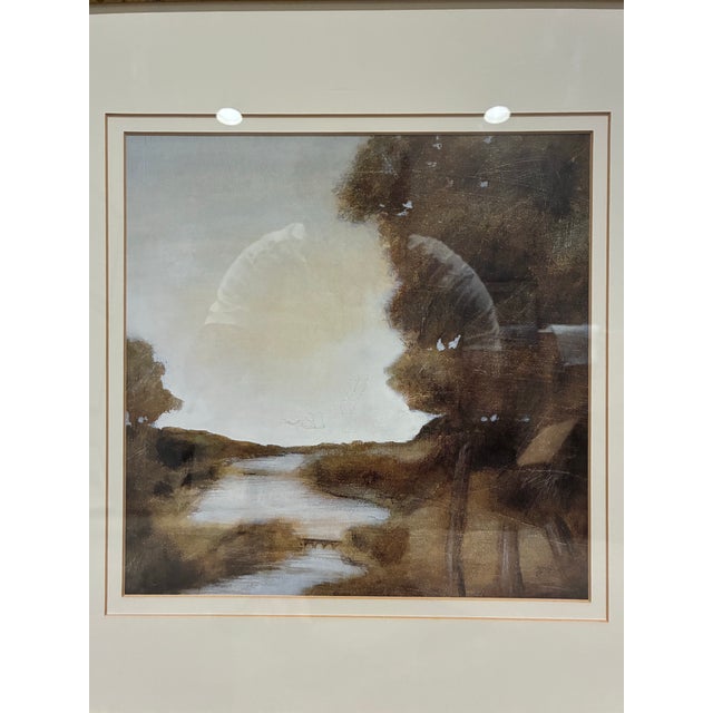 An elegant framed landscape print by Trowbridge, depicting a peaceful winding stream surrounded by softly rendered trees...