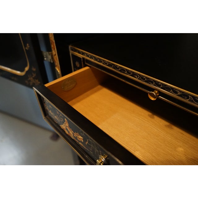 Simply stunning, ornate, black lacquer cabinet from The Stately Homes Collection by Baker Furniture. It features two...