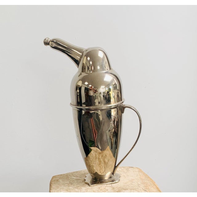 A silver plated cocktail shaker in the shape of a penguin made by Restoration Hardware in the 1990s. It was part of a...