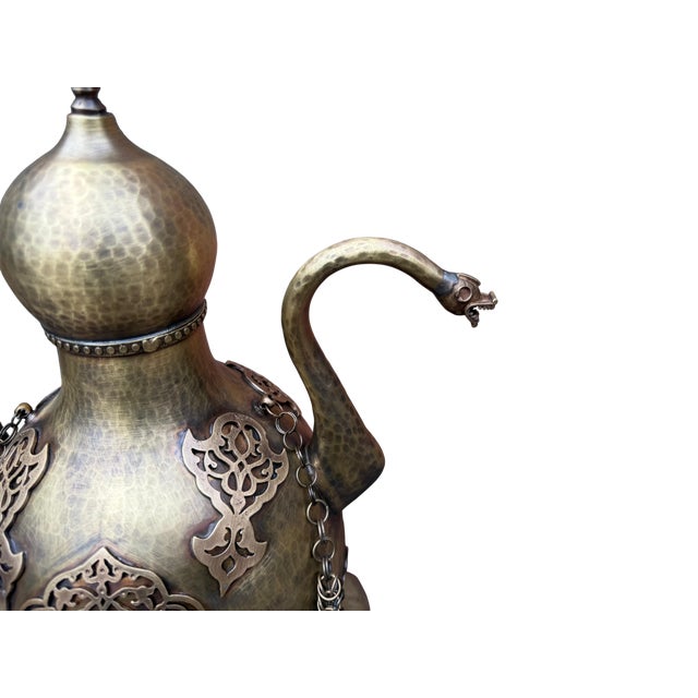 A significant example of traditional metalworking, this heavy brass ewer is defined by its architectural complexity and...
