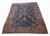 Hand-knotted antique Persian Sarouk carpet featuring a rich midnight navy field framed by a striking terracotta-red...