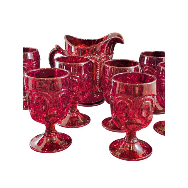 This L.E. Smith pitcher and cup set is a wonderful ruby red shade in the Moon and Stars pattern. There are a couple minor...