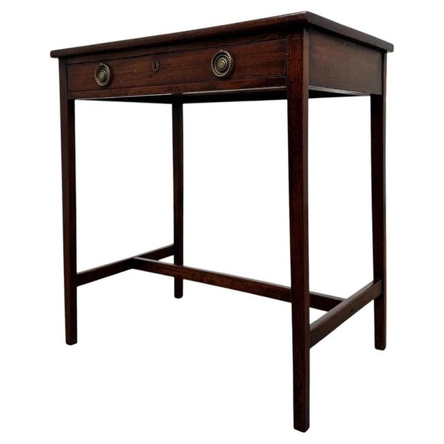 A charming 18th-century English Georgian side table, finely crafted from mahogany and distinguished by its elegant tapered...