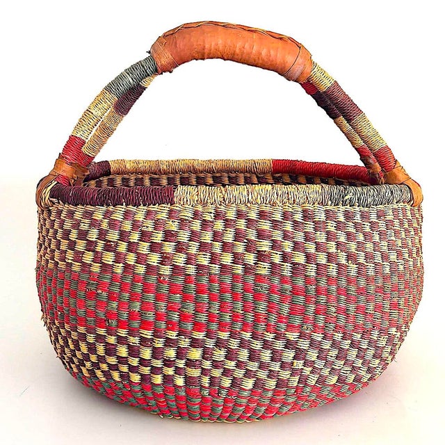 Offered is a hand woven Bolga Grass market basket with a leather wrap around the handle. Bolga baskets are handmade in...