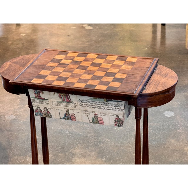 A compact and characterful rosewood game table with a inlaid chessboard top that lifts to reveal a shaped well below. The...