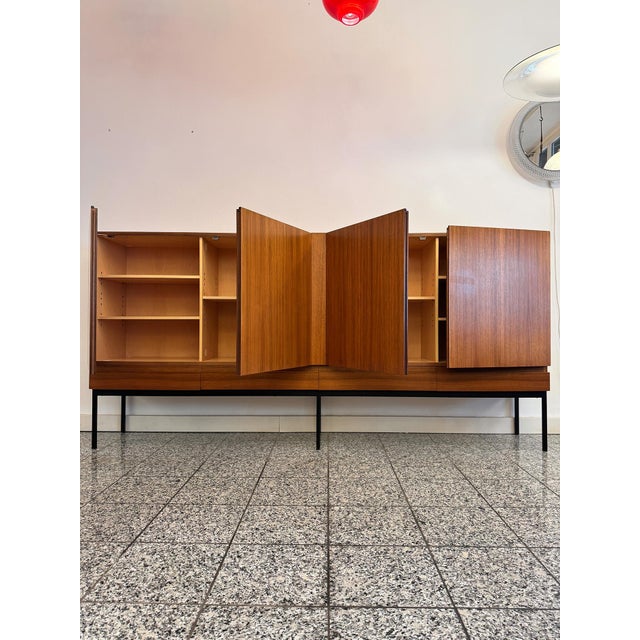 A highboard/sideboard * by Dieter Wäckerlin for Behr International * made of teak * steel legs * circa 1957 Dimensions: *...