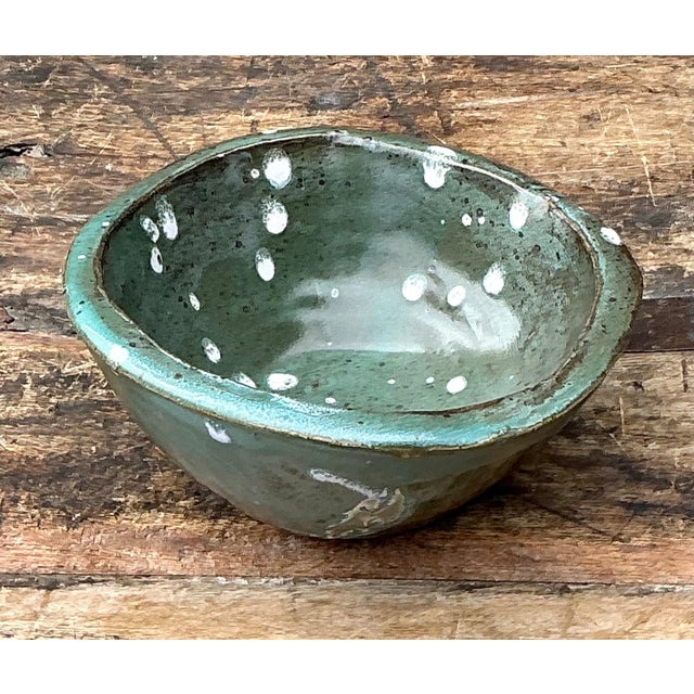 This vintage green glazed studio pottery bowl is a compelling example of mid-century ceramic artistry, celebrating the...