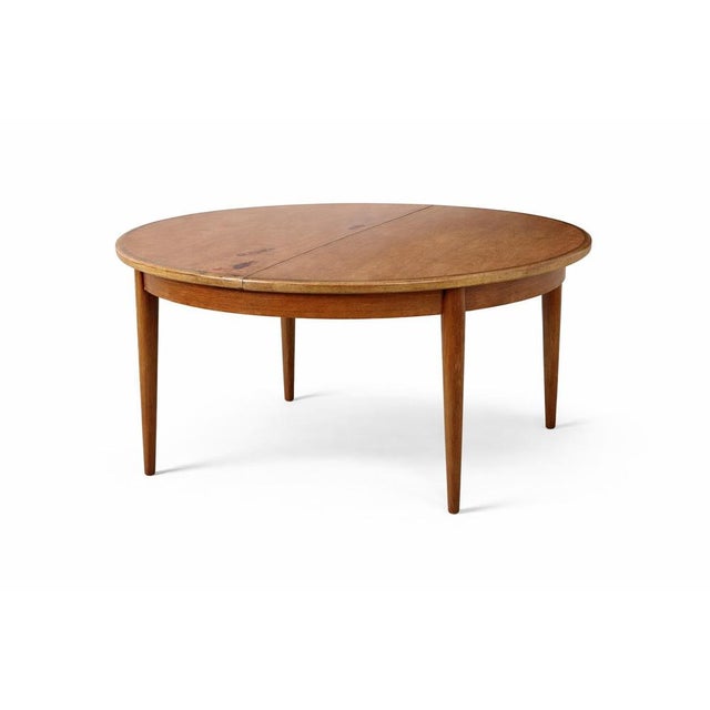 A classic g plan round teak extending dining table, dating from the mid-century period and showcasing the clean,...