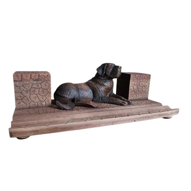 This item was carved in Germany in the Black Forest region A carved figure of a Bernese Mountain Dog with glass eyes is...