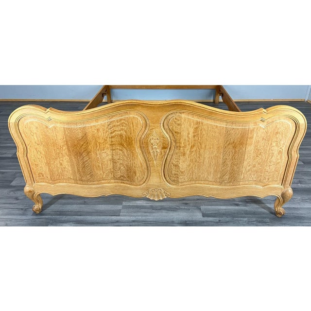 A striking Vintage French Louis style double bed frame in beautifully grained oak, featuring flowing lines and refined...