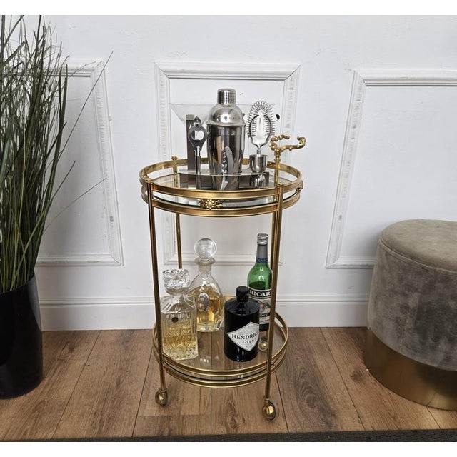 Beautiful and stylish vintage 1970s Italian two-tier round brass and glass bar cart with brass wheels. Very good condition...