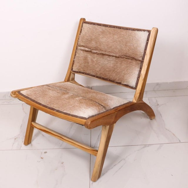 Our Natural Teak and Genuine Leather Chair is a masterpiece of artisanal craftsmanship, featuring a solid Teak wood frame...