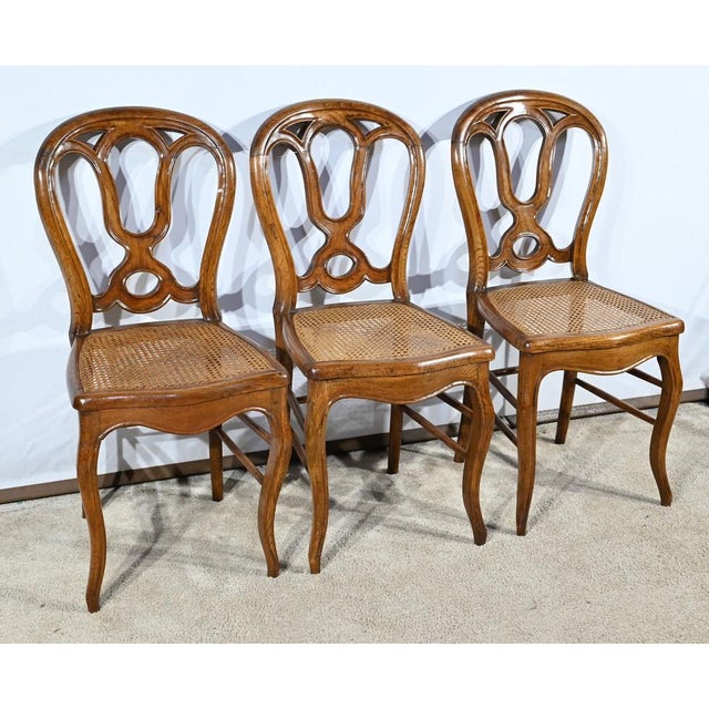 These period chairs in solid oak are distinguished by their S-arched crowbar legs supporting caned seats with scrolled...