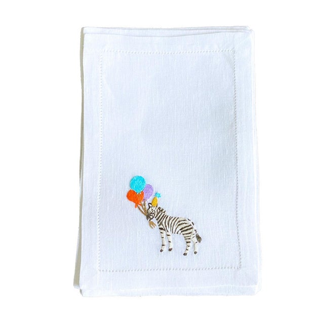 Celebratory, hand embroidered zebras adorn these whimsical cocktail napkins. 6in. x 9in. fold-over napkins. 100% pure...